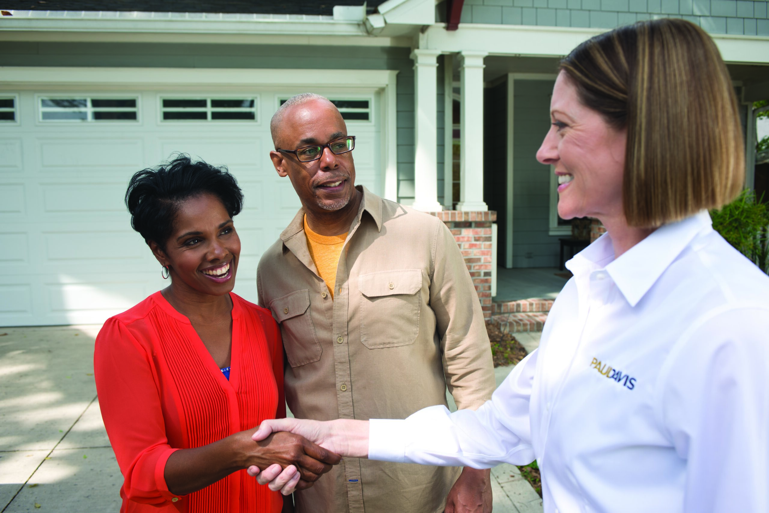 Paul Davis Restoration representative shaking hands with homeowners outside their house, showcasing trusted restoration services in San Francisco